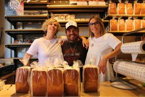 El actor y cantante cántabro Jimmy Barnatan posa sonriente junto a las dos mujeres propietarias de Sobaos Arce